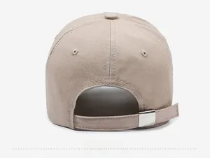 Close-up of the adjustable strap and silver metal buckle on the beige cotton baseball cap