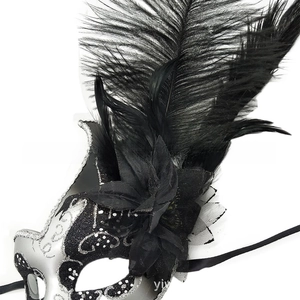 Dettaglio della maschera con piume nere, glitter argento e decorazioni in rete