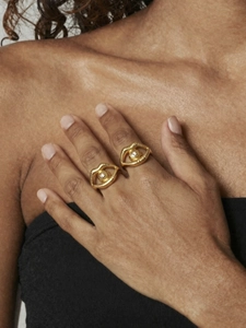 Detailed view of gold plated eye shaped rings with zircon stones and ripple texture