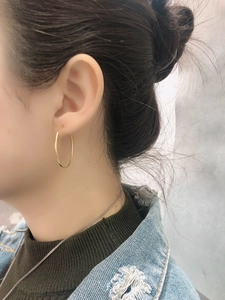 Minimalist gold hoop earring worn on ear showing its classic circular design and slim profile