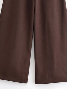 Dettaglio ravvicinato di pantaloni a gamba larga marrone scuro a vita alta con texture