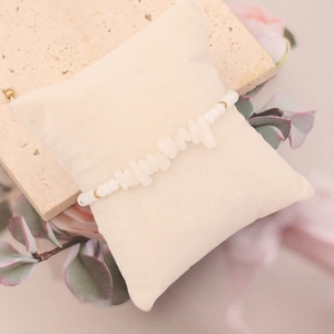 Macro detail of Bohemian bracelet with natural white stones and gold bead accents