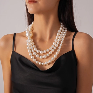 Elegant three-layer faux pearl necklace with oversized bead accent on female model
