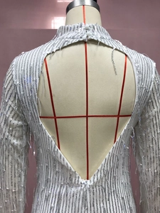Detalle de vestido de lentejuelas blancas con espalda abierta y cierre de cuello alto fino