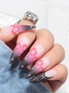 Macro view of long stiletto nails with pink to black gradient and cherry star pattern