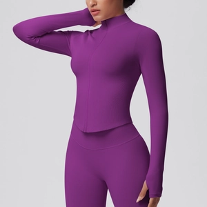 Side view of dark purple yoga set featuring a zip jacket with thumbholes and leggings