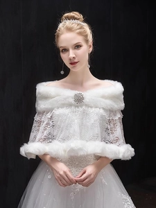 Detail of white faux fur bridal shawl with lace texture and crystal brooch buckle