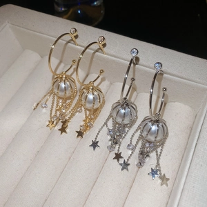 Detailed view of silver needle tassel earrings with pearls and zircon star pendants
