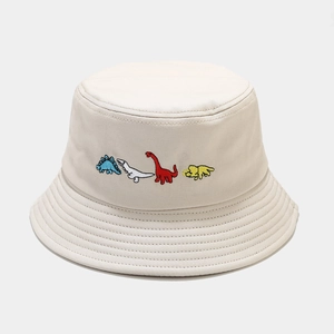 Close-up of four colorful mini dinosaur embroidery on a beige cotton bucket hat