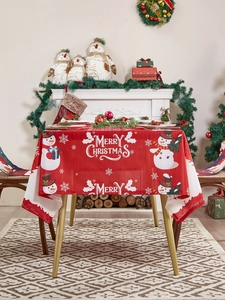 Detail van het rode kersttafelkleed met sneeuwpopmotief en Merry Christmas tekst