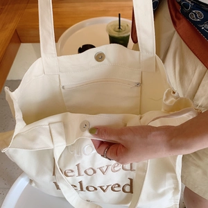 Détail du sac cabas en toile blanc cassé avec broderie beloved et poche intérieure zippée