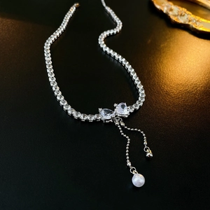 Detail view of heart zircon necklace featuring elegant pearl tassels and tennis chain