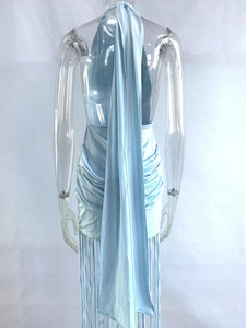 Detail of light blue halter dress featuring a long back sash, ruching, and fringe hem