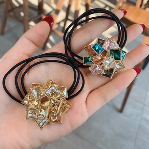 Close-up of sparkling rhinestone hair ties in champagne gold and colorful crystal designs