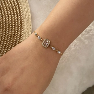 Vue macro d'un bracelet doré avec cristal rectangulaire et pierres ovales
