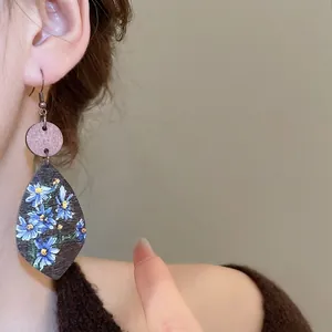 Bohemian teardrop wooden earrings with blue floral prints in vintage ethnic style