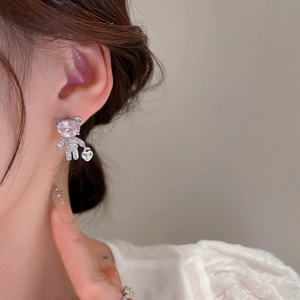 Detail of silver bear earring with pink stone and white zircon on a model's ear