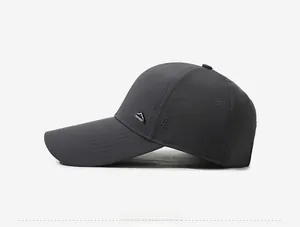 Detail of dark grey baseball cap with laser-cut side vents and mountain metal badge