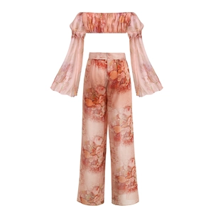 Detailed view of floral print crop top and high waist wide leg pants set on white background