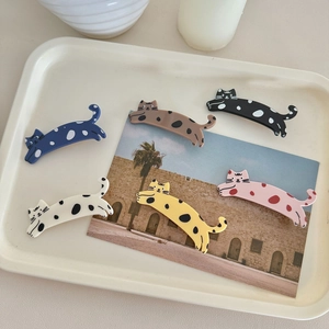 Set of 6 cute colorful spotted cat hair clips in various colors on a cream tray