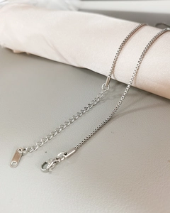 Detailed close-up of a silver stainless steel box chain with lobster clasp and extender