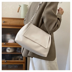 Sac à épaule beige en similicuir avec chaîne argentée dans un décor intérieur
