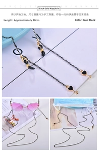 Close-up of dual-use black eyeglass chain with heart key pendant on sunglasses and mask