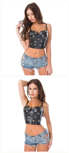 Dettaglio del bustier in pelle con borchie a stella e mini shorts in denim délavé