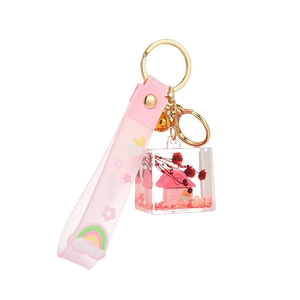 Cute pink liquid oil keychain featuring silicone wish strap and house charm in acrylic cube