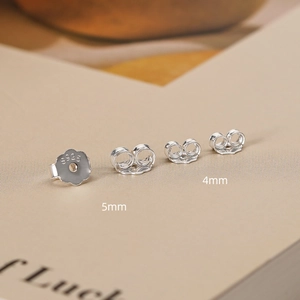 Macro shot of 925 sterling silver earring backs showing 4mm and 5mm size S925 stamps