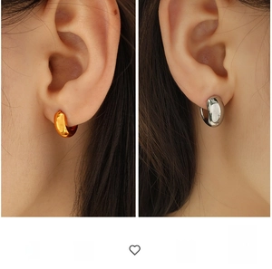 Close-up of chunky gold and silver polished hoop earrings on model for visual comparison