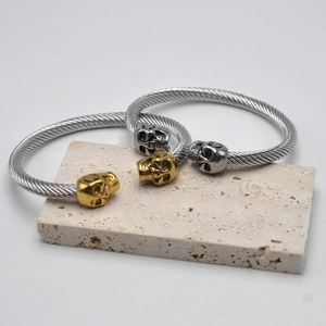 Detailed shot of hip hop skull cable bracelets in gold and silver finish on stone