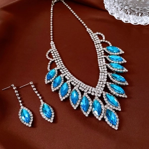 Detailed macro view of French style blue teardrop pendant necklace and fringe earrings set