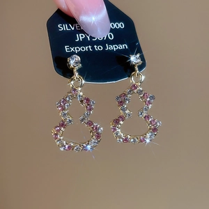 Detailed view of gourd-shaped silver earrings with pink and white cubic zirconia stones