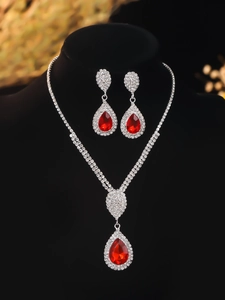 Detail of red teardrop gemstone necklace and earring set on black mannequin display