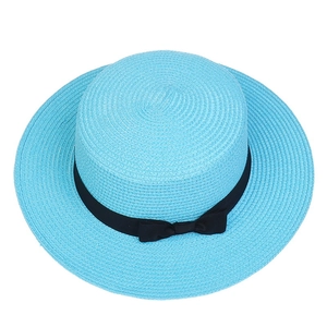 Detail of blue straw hat with black ribbon bow, showing fine woven texture for sun protection