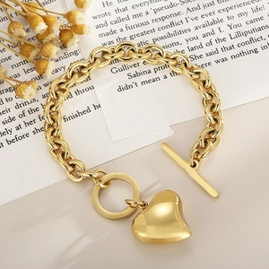Vista detallada de una pulsera dorada con corazón y cierre en T estilo vintage