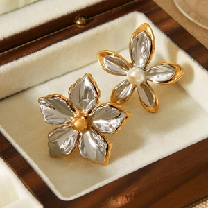 Detailed macro view of two-tone flower jewelry with pearls inside a walnut wood box