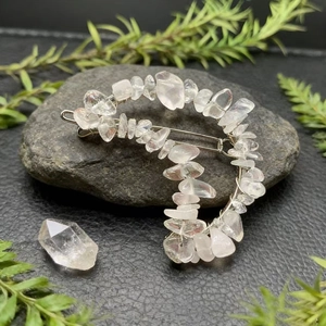 Detail view of natural crystal stones on a moon-shaped hair clip with elegant metal wire