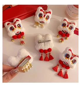 Macro detail of Chinese lion dance hair clip with plush fur, red tassels and golden bell