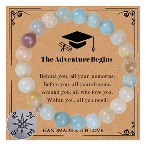 Detail of beaded gemstone bracelet with compass pendant on graduation gift card