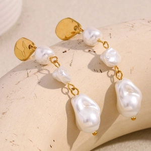 Detailed macro view of 18K gold plated drop earrings with three baroque pearls