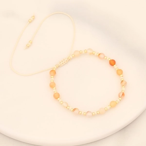Detail of bohemian woven bracelet with natural stones and adjustable beaded string
