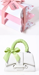 Detail of pink and red satin ribbons tied in bows on gift boxes and handbag handles