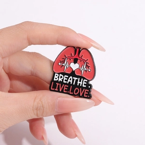 Lung enamel pin with heart and EKG line featuring Breathe Live Love slogan decoration