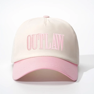 Close-up of OUTLAW 3D embroidery on two-tone cream and pink cotton baseball cap