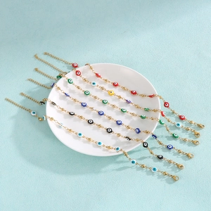 Gold stainless steel evil eye bracelets set with colorful beads on a white tray