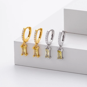 Close-up of 925 sterling silver earrings with zircon pavé and emerald cut yellow stones