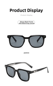 Detail view of glossy black square sunglasses with dark grey lenses and silver metal accents