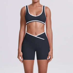 Detail of cross-waist design on black two-piece yoga set with white trim accents